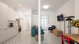 a living room with a blue couch and a kitchen at LSA Castelo S Jorge by Numa in Lisbon