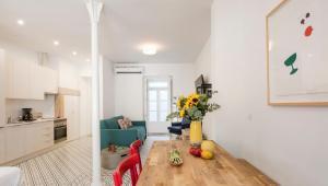 a kitchen and living room with a wooden table and chairs at LSA Castelo S Jorge by Numa in Lisbon