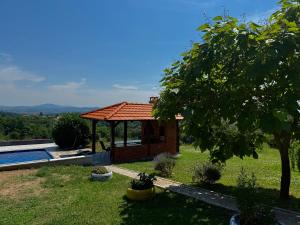 a small house with a gazebo in a yard at Kosmaj-Suncani Breg in Drlupa