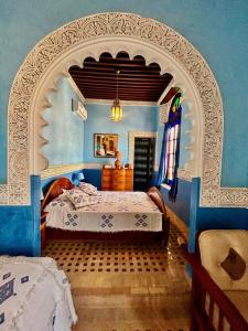 a bedroom with a bed in a blue room at Riad Fes Baraka Piscine & SPA in Fez