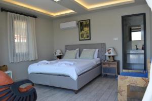 a bedroom with a large bed and a chair at Çökertme Butik Otel in Çökertme