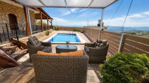a patio with wicker chairs and a swimming pool at Villa Maria Christina with Private Pool in Crete in Skoúrvoula