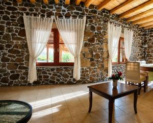 a living room with a table and a stone wall at Villa Maria Christina with Private Pool in Crete in Skoúrvoula