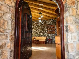 a large wooden door in a room with a stone wall at Villa Maria Christina with Private Pool in Crete in Skoúrvoula