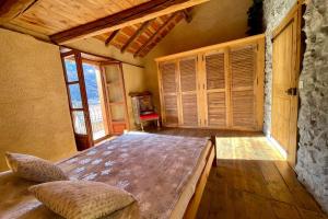 a bedroom with a large bed in a room with windows at 130 sqm Apartment in a Village House in La Salle-les-Alpes