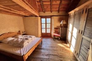 a bedroom with a bed in a room with a window at 130 sqm Apartment in a Village House in La Salle-les-Alpes