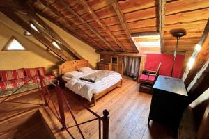 an attic bedroom with a bed and a wooden ceiling at 130 sqm Apartment in a Village House in La Salle-les-Alpes +10 photos
