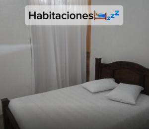 a bed with two pillows and a sign that says hallucinations at Casa de Descanso la Cascada in Sopetrán