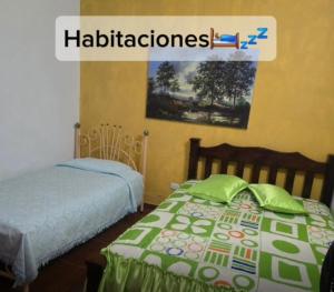 a bedroom with two beds and a picture of hallucinations at Casa de Descanso la Cascada in Sopetrán +3 photos