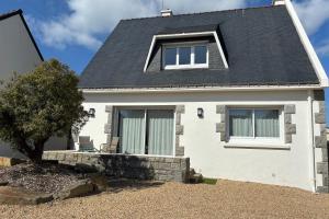 a white house with a black roof at Maison proche centre ville in Quiberon