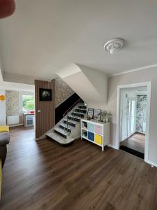 a living room with a staircase and a room with wood floors at Maison proche centre ville in Quiberon