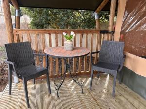 two chairs and a table on a deck at GLAMPING by SUNBEAM in Leporano Marina