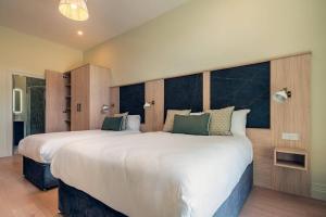 a bedroom with two large beds with green pillows at The Malt Store in Birr