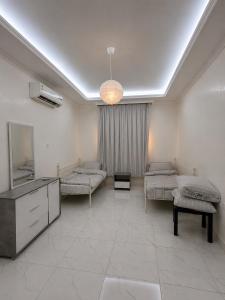 a hospital room with two beds and a mirror at Al Rabi Rest House in Khor Fakkan