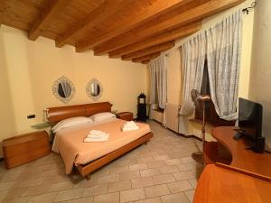 a bedroom with a bed and a flat screen tv at Hotel Adria & Resort in Toscolano Maderno +87 photos