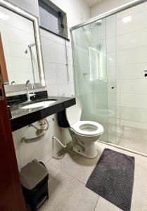 a bathroom with a toilet and a shower and a sink at Hotel Caeté in Bragança +18 photos