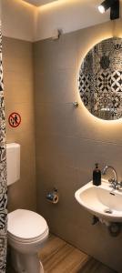 a bathroom with a toilet and a sink at Merryland Studios & Apartments in Kremasti +26 photos
