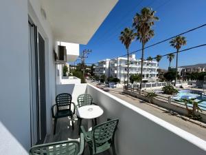 a balcony with a table and chairs and a view of a street at Kaloxenia in Kardamaina