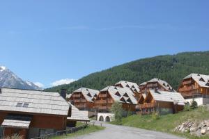 a group of wooden houses in a mountain village at Chalets de Praroustan by Actisource in Pra-Loup +2 photos