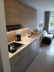 a kitchen with white cabinets and a sink at Apartament 112 Mielno in Mielno