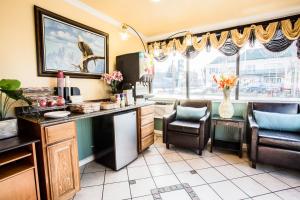 a kitchen with a counter and chairs and a window at Budget Inn of America in Medford