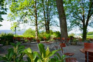 a patio with tables and chairs and trees at Berggasthof Hinhart in Regen