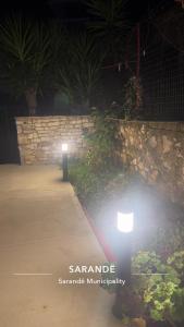 a light on a sidewalk next to a stone wall at Joal Rooms in Sarandë