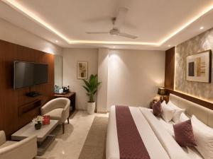 a hotel room with a bed and a tv at Airport NH Skye Suites Hotel Terminal 3, Delhi International Airport With - Free Airport Pickup in New Delhi