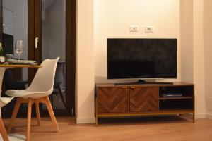a living room with a television on a wooden entertainment center at UrbanSuite Torino in Turin