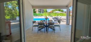 a dining room with a table and chairs and a pool at Kuća za odmor Veronika in Klobuk