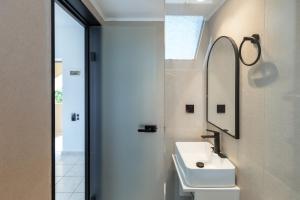 a bathroom with a sink and a mirror at Sunny Vibes by Estia Adults Only in Stalís +13 photos