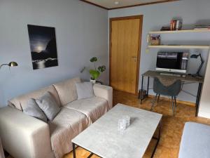 a living room with a couch and a table at Rom 4 i bufellesskap in Sogndal