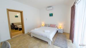 a bedroom with a white bed and a living room at Kuća za odmor Veronika in Klobuk +96 photos