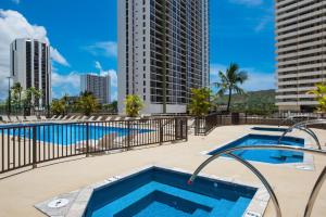 a swimming pool with a view of buildings at Sky-high condo with lanai & beach access in Honolulu