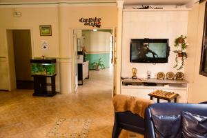a living room with a tv and a fish tank at Nova Vicenza Hotel in Farroupilha