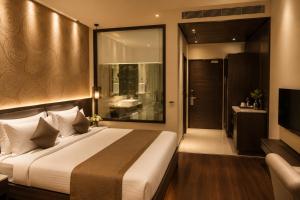 a hotel room with a bed and a television at Hotel Paarth in Ludhiana +7 photos
