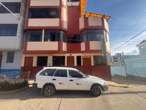 a white car parked in front of a building at MyAbancayHome in Abancay