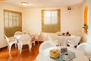 a dining room with white tables and white chairs at Capital O Hotel Meson Del Rio, Tepotzotlan in Tepotzotlán