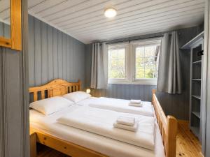 a bedroom with a large bed with white sheets at Cottage Yard - cozy Cabin in Geilo