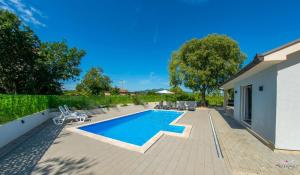 a swimming pool in the backyard of a house at Kuća za odmor Veronika in Klobuk