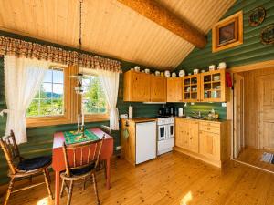 a kitchen with green walls and a table and chairs at Cottage Yard - cozy Cabin in Geilo