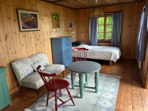 a bedroom with a bed and a table and chairs at Lommen in Dals Långed