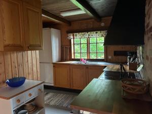 a kitchen with wooden cabinets and a white refrigerator at Lommen in Dals Långed +10 photos