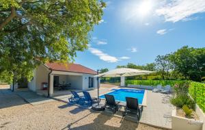 a swimming pool with chairs and an umbrella at Kuća za odmor Veronika in Klobuk