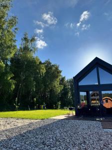 a pavilion with a person sitting on a bench in a park at Domek BrzozoweLove in Szczodrowo