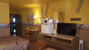 a room with a room with a bed and a television at Earth Inn Motel - Jackson in Jackson