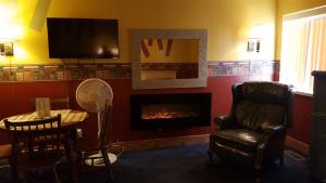 a living room with a fireplace and a table and a chair at Earth Inn Motel - Jackson in Jackson