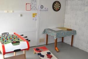 a toy room with a table and a refrigerator at Gîte les Grands Orangers in Melle