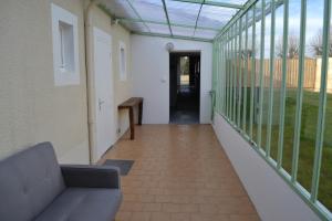 a corridor of a building with a couch on a balcony at Gîte les Grands Orangers in Melle