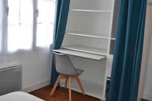 a closet with a chair and a blue curtain at Gîte les Grands Orangers in Melle